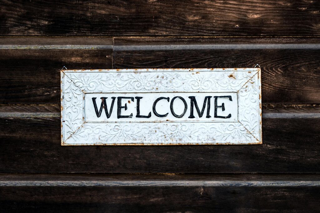 A rustic vintage-style 'Welcome' sign on a wooden wall creating a warm and inviting atmosphere.