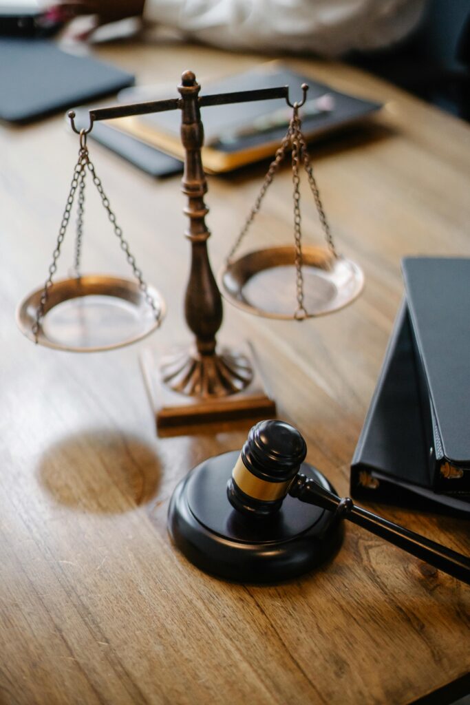 A striking image featuring a brass justice scale and gavel on a wooden desk, symbolizing law and justice.